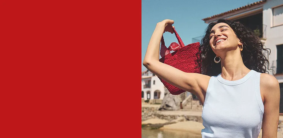 Sommerliches weißes Top, rote Handtasche und goldene Ohrringe – perfekt für einen sonnigen Tag.