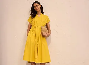 Sommerliches gelbes Hemdkleid mit Gürtel, knielang und kurzärmelig. Dazu schwarze Sandalen und Strohhandtasche.
