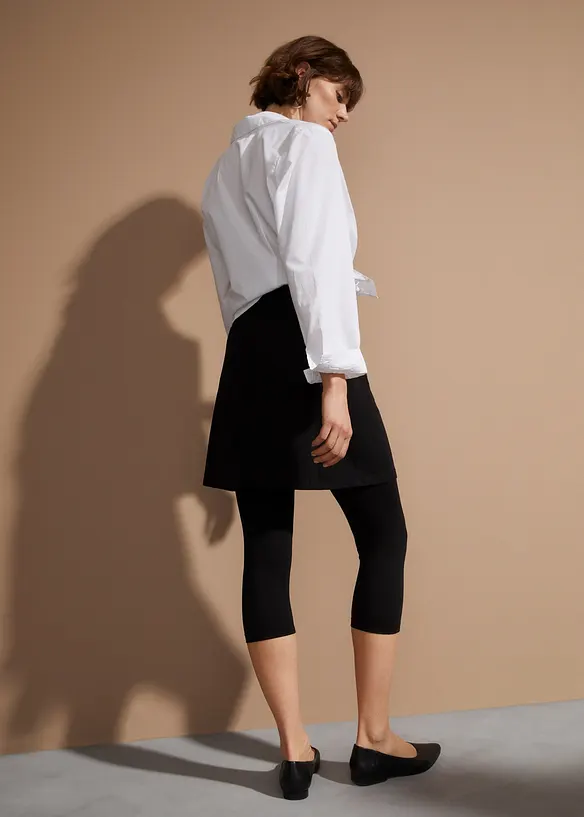 Capri-Leggings mit Rock aus elastischem Baumwoll-Mix in schwarz von hinten - bonprix